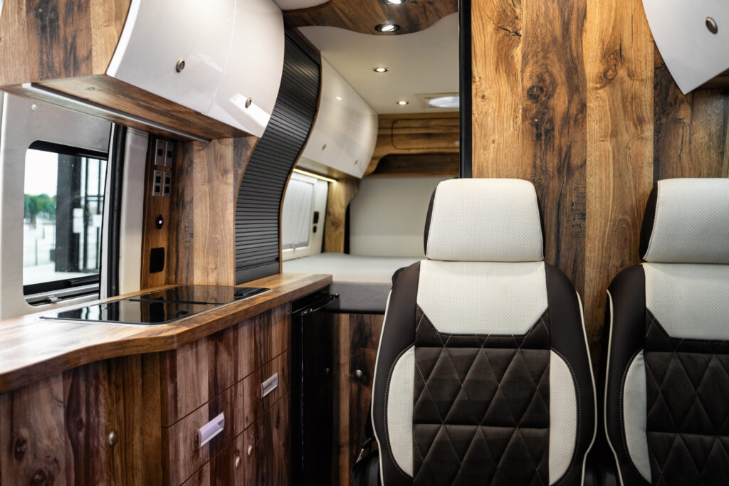 Wnętrze kampera z drewnianymi panelami i siedzeniami.