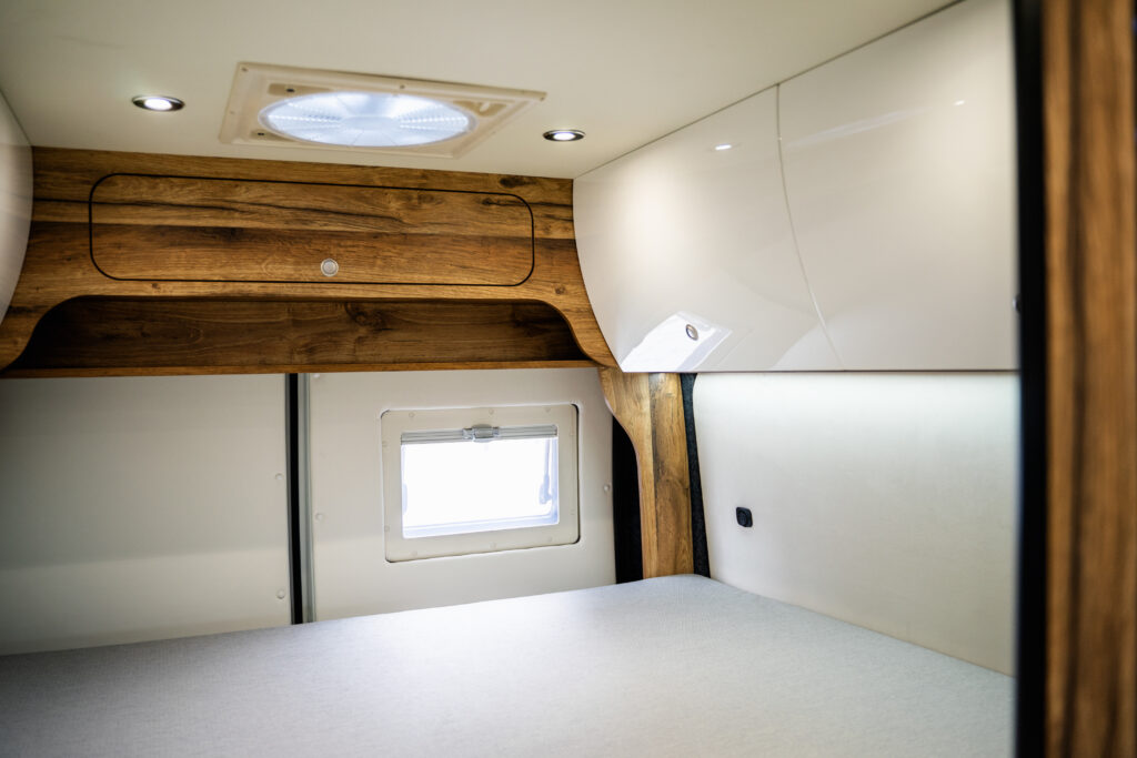 Wnętrze kampera z drewnianymi szafkami.